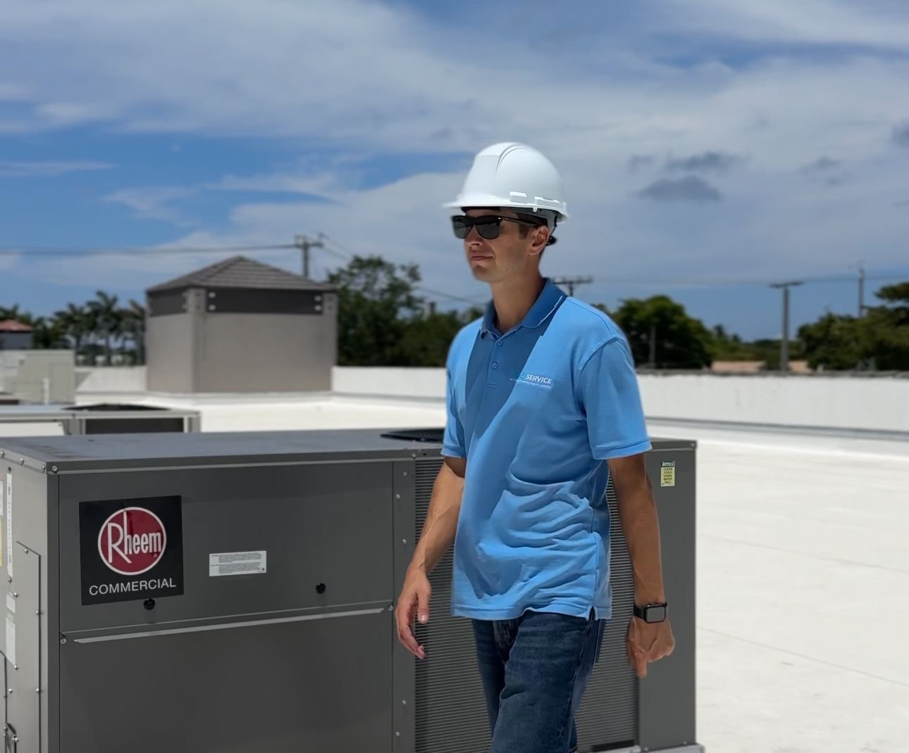 Airo Service technician on a South Florida rooftop beside a commercial condensing unit