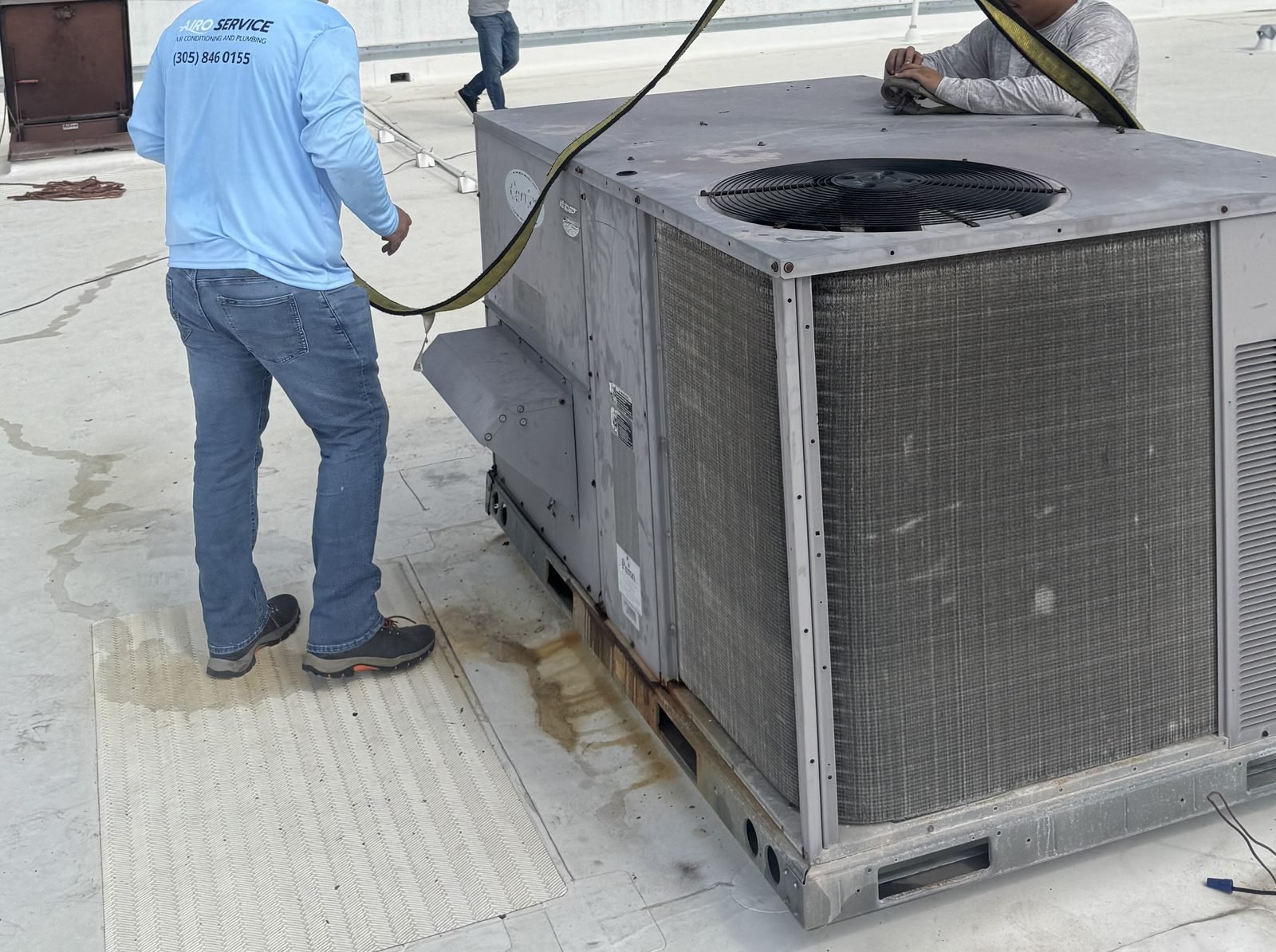 Airo Service technician working on installed outdoor HVAC equipment at a South Florida property