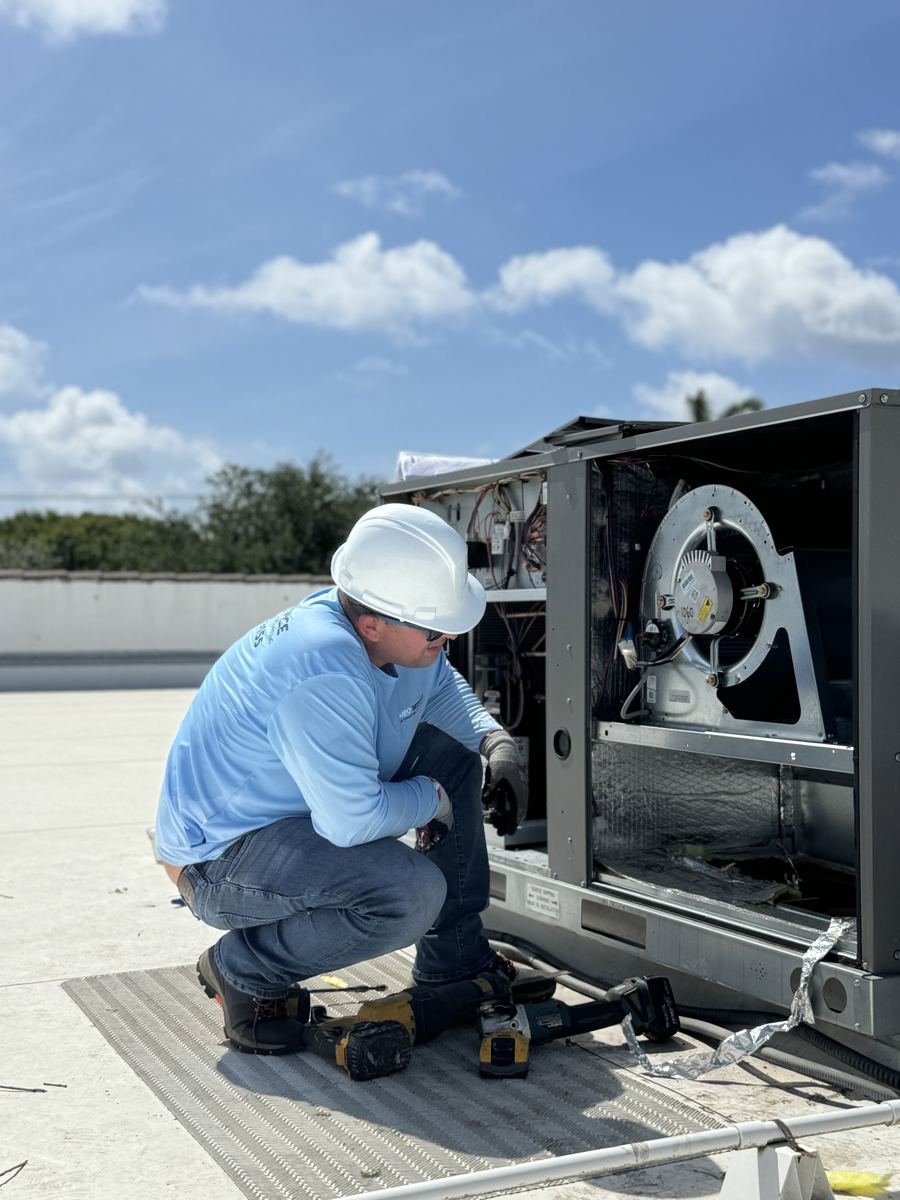 Airo Service certified technician servicing a commercial rooftop AC unit in South Florida